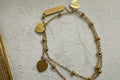 Gold double bracelet with heart-shaped charms.