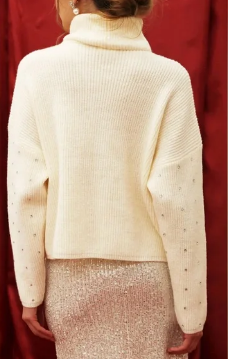 Cream-colored sweater with gem embellishments