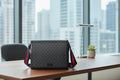 Black patterned shoulder bag with red and blue straps 